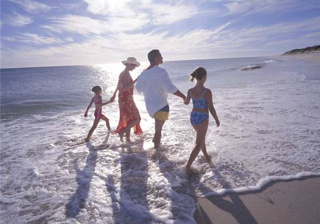 一家人一起在海邊踏浪